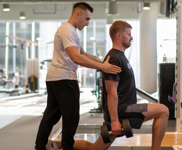 trainee doing split squats with trainer