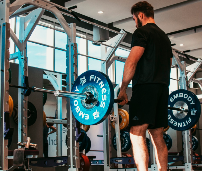 man holding straight barbell weight