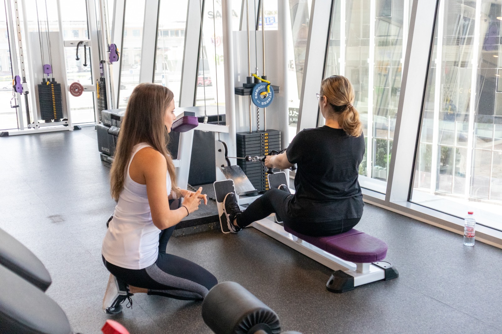 woman doing seated row with woman instructor