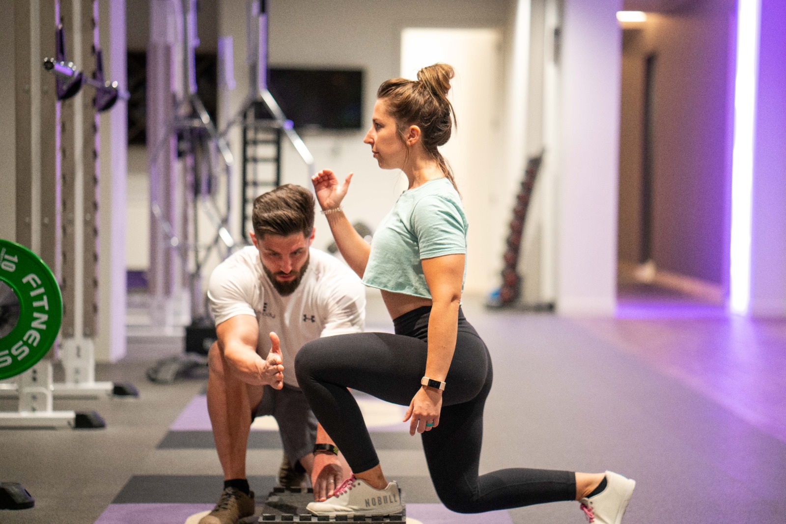 woman doing squats with trainer